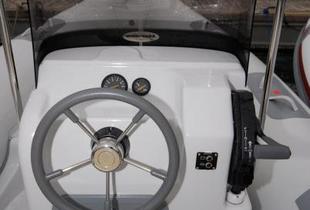 Console de pilotage avec pare-brise efficace, poignée de gaz bien placée, et de la place pour installer l’écran sondeur GPS.Mais,en pilotage assis, on ne voit pas les cadrans derrière le volant.
