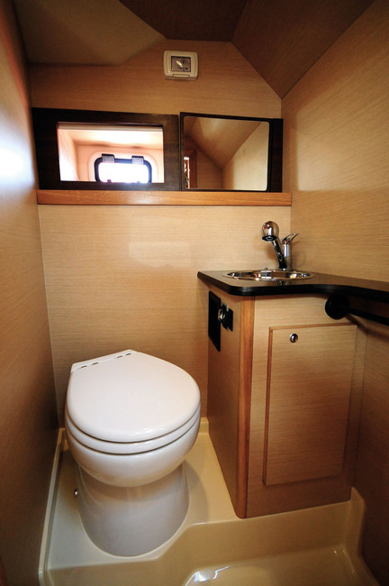 La salle d'eau, avec douche et WC, est bien aérée et offre 1,78 m de hauteur sous barrots. 