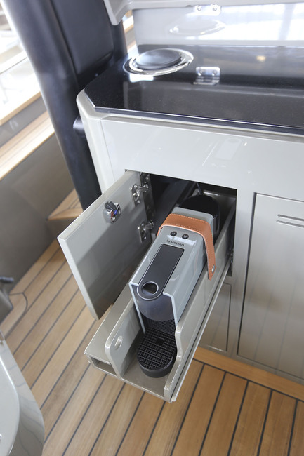 Le bloc-cuisine adossé aux sièges de pilotage comporte un frigo mais aussi un seau à champagne et, surtout, une machine à café dans son rangement dédié.