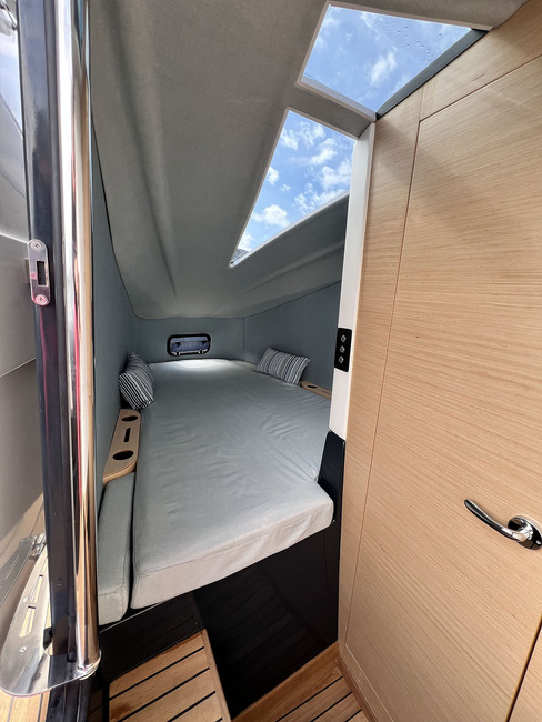 La cabine, avec porte latérale, possède un bel éclairage au-dessus du couchage double et un cabinet de toilette simple, mais complet.